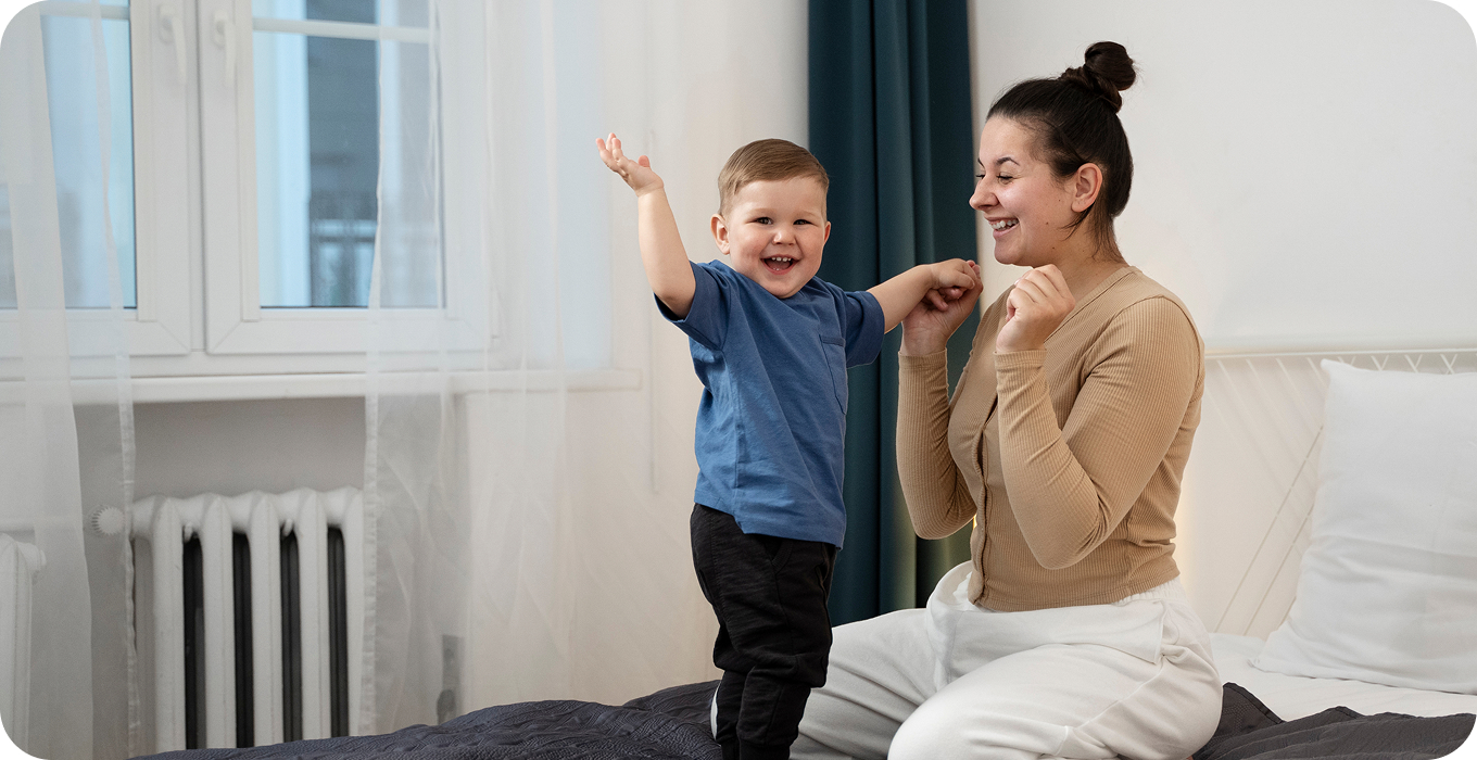 A happy mother playing with her young son at home